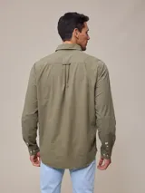 Camisa de manga larga para hombre, confeccionada en algodón con efecto peach (textura suave). Presenta un estampado de cuadros vichy en tonos azul marino y blanco, cuello con botones y un bolsillo de parche en el pecho izquierdo.