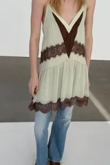 Vestido corto de tirantes finos ajustables con escote en pico. Presenta un diseño en color crema con detalles de encaje en color marrón a contraste en el escote, la cintura y el ruedo. Incluye forro interior.