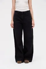 Jean de corte baggy con silueta amplia y relajada desde la cintura hasta el bajo. Presenta tiro bajo y diseño de cinco bolsillos con costuras laterales reforzadas.