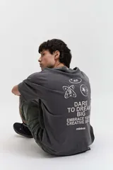 Remera gris oscuro con efecto gastado, corte boxy, manga corta y cuello redondo. Estampado en el frente con diseño abstracto y texto 'mistral'.