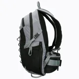 Mochila técnica de 22 litros marca Merrell, diseñada para actividades outdoor. Presenta un diseño bicolor en gris y negro, con múltiples compartimentos, bolsillos laterales para botellas, respaldo acolchado con malla transpirable, cinta frontal tipo daisy chain para accesorios y correas ajustables con silbato de emergencia.