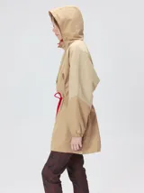 Campera tipo piloto con capucha, cierre frontal con botones y detalle de costuras en zigzag. Presenta cordones ajustables en la cintura y capucha, puños elásticos y logo bordado en el pecho.