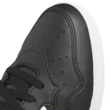 Championes de corte medio Adidas Hoops 4.0 Mid, color negro con las icónicas tres tiras laterales en blanco y suela de goma blanca. Confeccionados en cuero sintético con detalles de gamuza en la puntera.