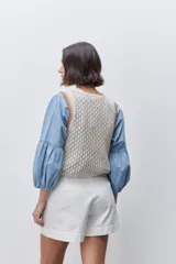 Short de tiro alto confeccionado en algodón, con calce relajado y silueta recta. Presenta pinzas delanteras, bolsillos laterales y botones decorativos en la cintura.