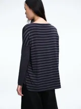 Camiseta de manga larga con cuello redondo y diseño a rayas horizontales en tonos gris y negro. Presenta un corte holgado y cómodo con caída fluida.