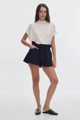 Blusa blanca de manga corta con cuello alto y calce holgado.