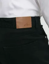 Pantalón de algodón sarga con elastano, diseño de cinco bolsillos con cierre de botón metálico y bolsillos traseros de parche.