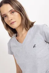 Remera de algodón gris melange con cuello en V y manga corta. Presenta un pequeño bordado en el pecho izquierdo.