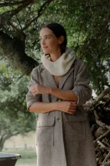 Tapado de corte recto y largo medio, confeccionado en tela con textura tipo espiga en tonos tierra. Presenta solapas clásicas, cierre frontal con botones grandes y dos bolsillos frontales de parche.