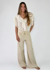 Pantalón largo de lino a rayas beige y blancas, con tiro medio, cintura elástica con cordón de ajuste y bolsillos laterales.