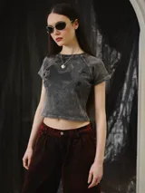 Remera baby tee de algodón gris con efecto stone wash, calce ajustado al cuerpo y largo corto, con mangas cortas y cuello redondo. Cuenta con un gran estampado en serigrafía de un animal mitológico en la parte frontal.