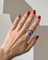 Anillo de plata 925 con diseño calado en forma de ojo, esmalte azul y piedra central.