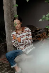 Remera de manga larga con cuello polo y cierre frontal de botones. Presenta un diseño a rayas horizontales en tonos bordó, blanco y celeste.