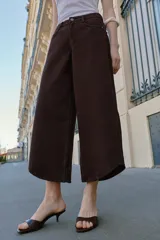 Jeans de tiro alto con diseño balloon, pernera ancha y corta, y bajo asimétrico. Cuenta con cinco bolsillos y cierre frontal con cremallera y botón.