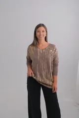 Sweater de punto color beige con escote en V y manga larga. Presenta un estampado de rayas verticales irregulares en color dorado.