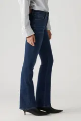 Jeans de corte bootcut con tiro alto, confeccionados en denim de lavado oscuro. Presentan un diseño clásico de cinco bolsillos, cierre de cremallera y botón metálico.