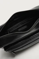 Bandolera de diseño rectangular con acabado suave, cuenta con compartimento principal con cierre de cremallera, bolsillo frontal con cierre y correa ajustable para el hombro.