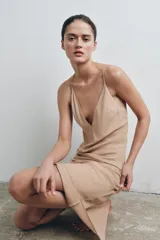 Vestido midi tipo lencero con escote en pico y tirantes finos ajustables que permiten diversas posiciones. Confeccionado en tejido satinado con caída fluida.