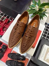 Zapato acordonado color marrón, con suela plana y cordones finos.