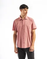 Camisa de manga corta color celeste claro, confeccionada en algodón, con cuello clásico y un bolsillo de parche en el lado izquierdo del pecho.