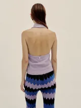 Pantalón tejido con diseño de ondas en tres colores: lila, azul y negro. Presenta pequeños calados en líneas verticales y cintura elastizada.