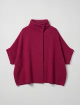 Capa tejida color fucsia, con cuello alto abotonado y mangas cortas estilo japonesa. Tejido de punto grueso.