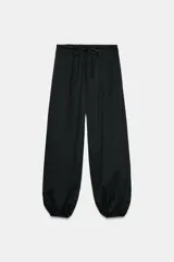 Pantalón negro de tiro medio con cintura ajustable mediante cordones y bajo abullonado con puño elástico.