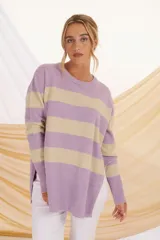 Sweater de punto lila con rayas horizontales color beige, de corte holgado y mangas largas.