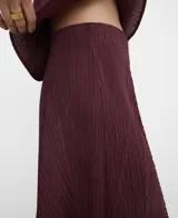 Pantalón palazzo bordó de tejido plisado (crinkle), con cintura elástica y godets centrales en delantero y espalda que aportan amplitud y movimiento.