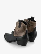 Botín de cuero marrón con detalles en rojo, de estilo texano, con puntera fina y taco bajo.