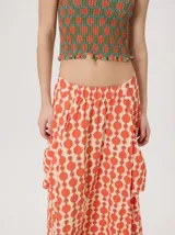 Falda midi de tiro alto y silueta evasé, confeccionada en algodón con diseño estampado geométrico en tonos verdes, naranjas y celestes. Cuenta con caída fluida, ruedo ligeramente acampanado y dos bolsillos cuadrados laterales.