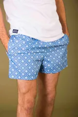 Short de baño con estampado geométrico de rombos en tonos celestes y blancos. Cuenta con cintura elástica ajustable con cordón y bolsillos laterales.