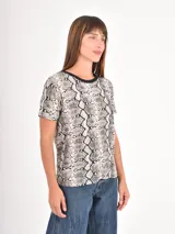 Remera de manga corta con cuello redondo, confeccionada con un estampado animal print de leopardo en tonos negros y beige.