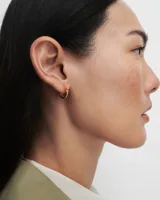 Aros de aro dorados con piedra ovalada color naranja.