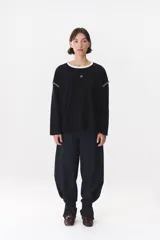 Remera de manga larga con corte oversized, color azul marino con cuello redondo en contraste color marrón. Presenta costuras decorativas a contratono hechas a mano en la zona de los hombros y logo bordado en el centro del pecho.