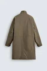 Parka relaxed fit de tejido técnico ligero, color verde militar, con cuello subido, manga larga y bolsillos de plastrón con solapa en la cadera. Cuenta con cintura ajustable con cordones y cierre frontal con cremallera oculta por solapa con botones a presión.