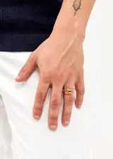 Anillo dorado con forma de clavo, fabricado en acero quirúrgico hipoalergénico.