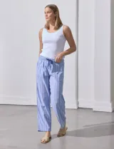 Pantalón de lino estampado a rayas verticales azules y blancas, marca DASH. Tiene pretina ancha elastizada con lazo ajustable.