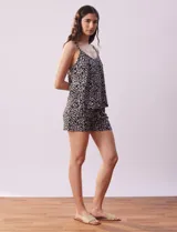 Set de pijama de tres piezas marca René Rofé, compuesto por un saco negro, una musculosa con estampado floral en blanco y negro y un short con estampado floral en blanco y negro.