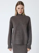 Suéter de cuello alto, color marrón oscuro jaspeado, de manga larga y calce holgado. Presenta puños y bajo acanalados con acabado enrollado.