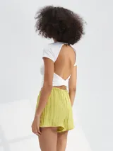 Short de tela liviana con textura arrugada, color negro, con cintura elástica y cordón ajustable.