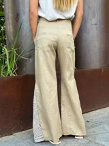 Pantalón de lino color beige, corte palazzo, con detalle de crochet en el lateral inferior.