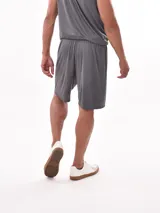 Short deportivo de corte holgado en color gris, confeccionado en tejido técnico con textura microperforada, cuenta con cintura elástica para mayor comodidad.