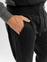 Pantalón de jogging de felpa color gris melange, con corte ajustado, cintura elástica con cordón de ajuste y bolsillos laterales con cierre.