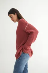Sweater tejido de punto color ladrillo, con cuello redondo y calce oversize.