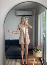 Conjunto color naranja compuesto por un chaleco sin mangas con solapas y un short de tiro alto con elástico en la parte trasera.