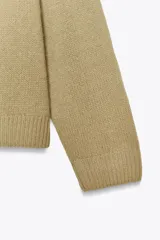 Jersey de punto confeccionado en lana 100%, con escote en pico y manga larga de corte holgado.