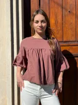 Blusa color chocolate de diseño holgado, con cuello redondo, frunce frontal y mangas abullonadas con puños ajustados.