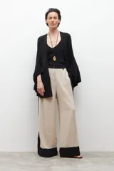 Capa tejida abierta de color negro, con mangas anchas y diseño fluido.