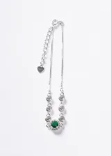 Pulsera de plata 925 con cadena veneciana, detalle central de piedra zirconia verde rodeada de pequeñas zirconias transparentes y zirconias engastadas a lo largo de la cadena. Cuenta con cadena de extensión y dije colgante en forma de corazón.
